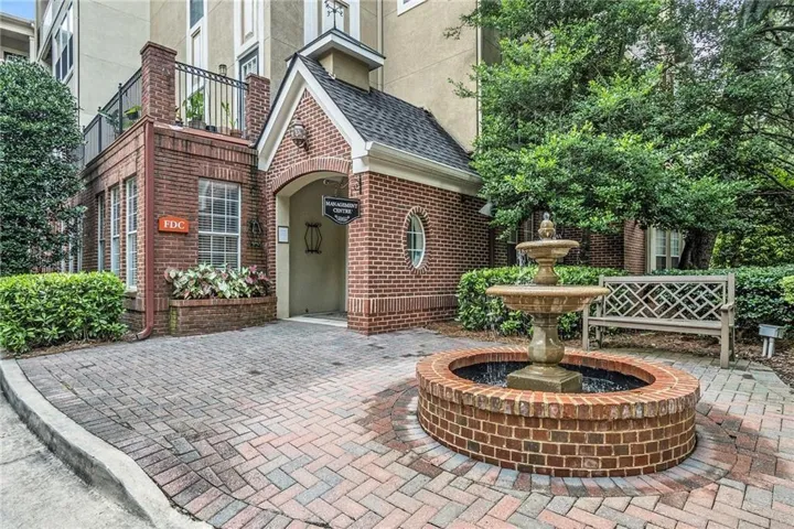 Brick exterior with a gabled entry, paver walkway, and an ornamental water feature