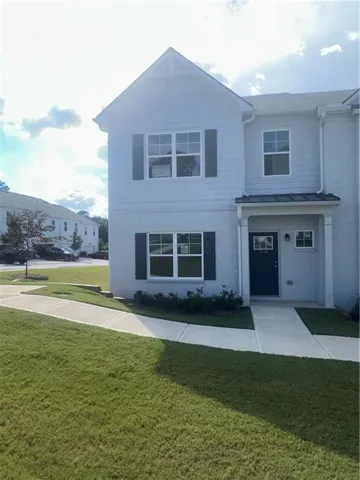 Two-story exterior with light-colored siding and brick, featuring dark window shutters, an inviting covered front entry, and a concrete pathway