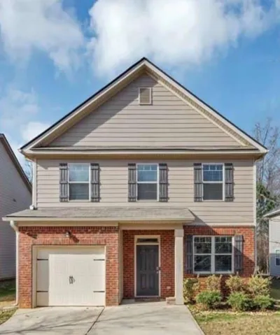 Two-story residence featuring a brick and siding facade, a single-car garage, and a covered entryway