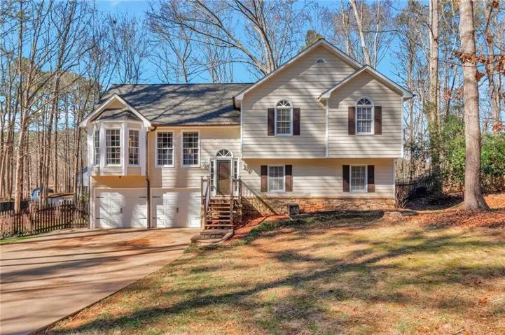 Raised ranch with concrete driveway and a garage
