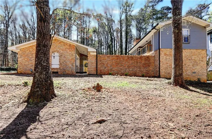 View of home's exterior featuring brick siding and a gate