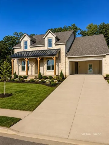 Brick exterior with a covered front porch featuring exposed wood pillars, dormer windows, a metal roof accent, and an attached garage