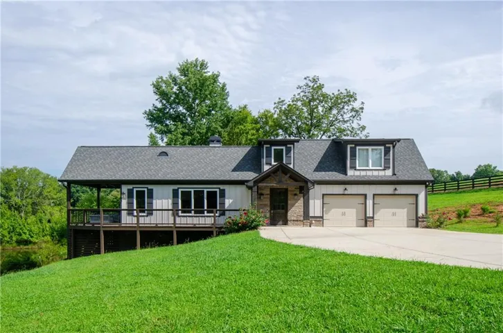 Contemporary exterior with a covered porch, two dormer windows, and a two-car garage