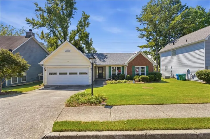 Brick and siding exterior with a gabled roofline, concrete driveway, and attached garage
