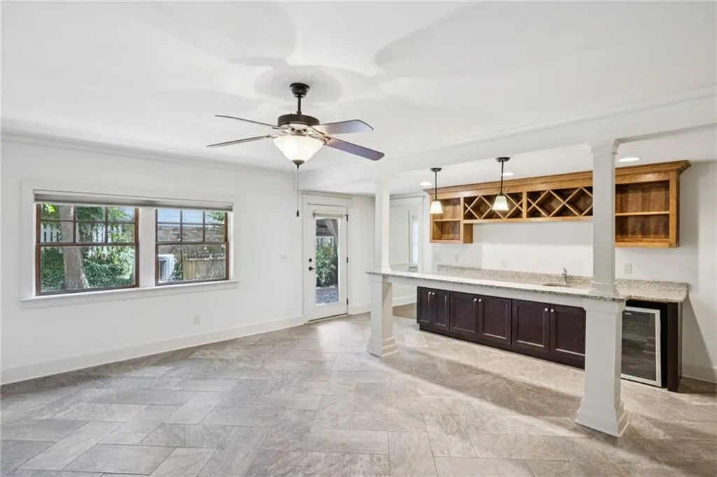 Lower level with stylish tile, barstool seating, and kitchen area.