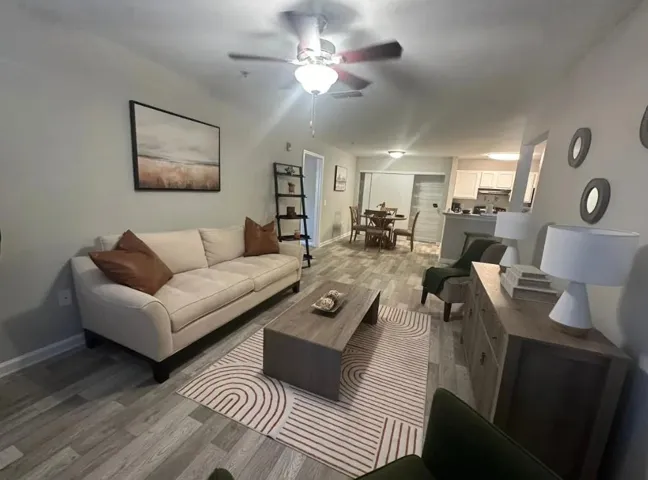 Living area with light wood-style floors and a ceiling fan