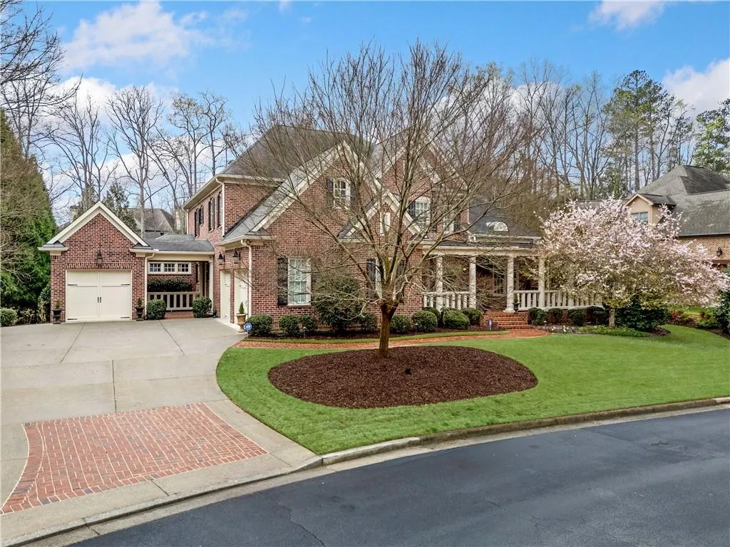 View of front of property featuring concrete driveway, a porch, brick siding, and a front lawn