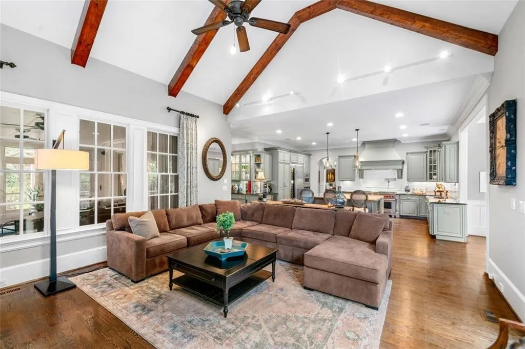 Great Room with Beamed Ceilings Looking into Kitchen with View of Screened in Porch