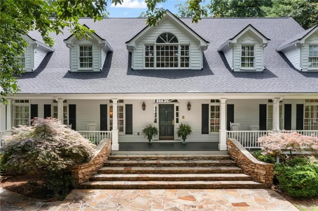 This timeless Buckhead beauty welcomes you with a gracious wraparound rocking chair porch that exudes Southern charm.