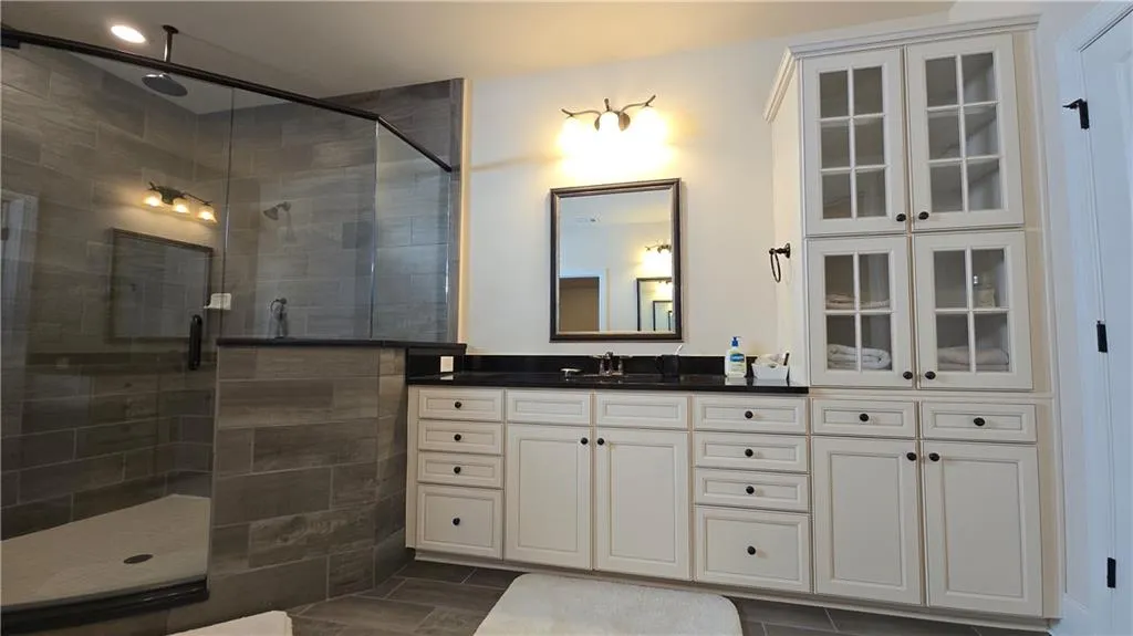 Full bath featuring vanity and a tile shower