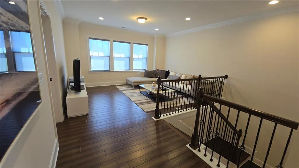 Stairway featuring recessed lighting, baseboards, hardwood / wood-style floors, and crown molding