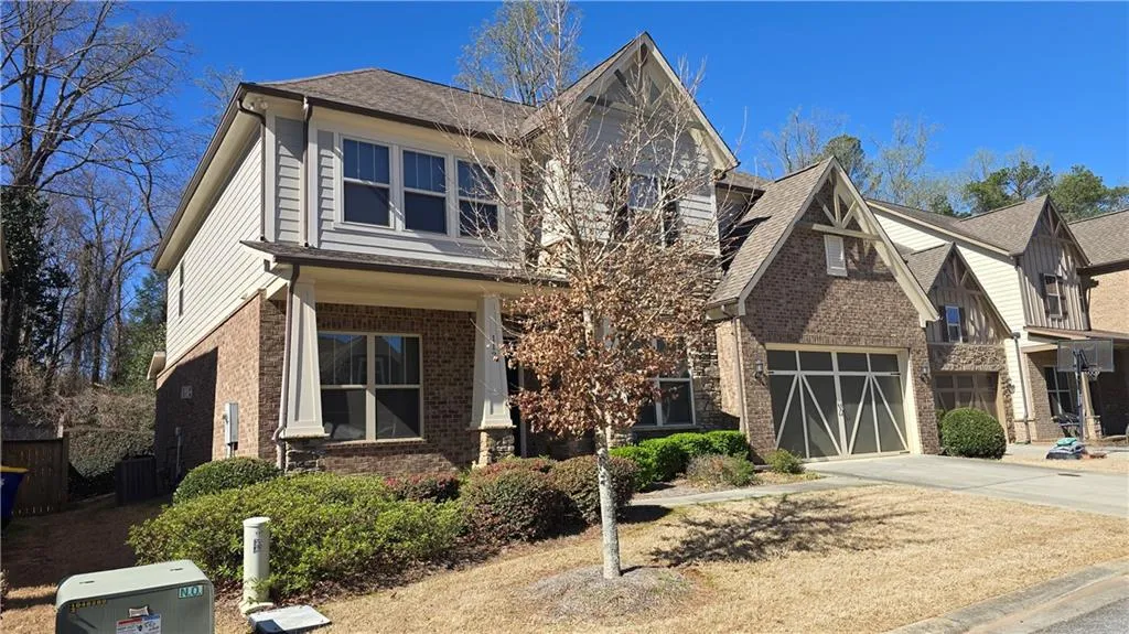 View of front of house featuring roof with shingles, central AC, concrete driveway, a garage, and brick siding