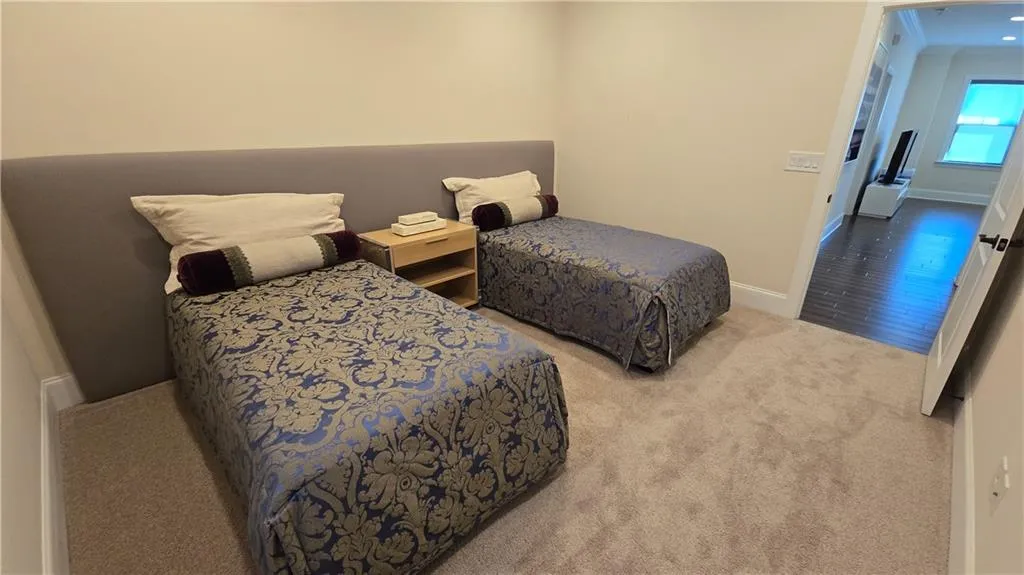 Bedroom featuring baseboards, carpet, and wood finished floors