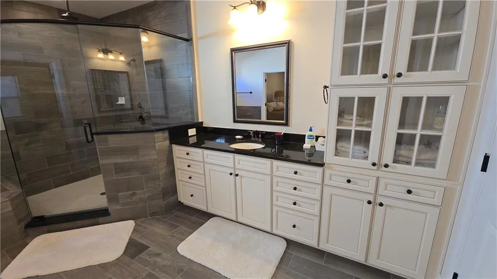 Full bath featuring vanity and a shower stall