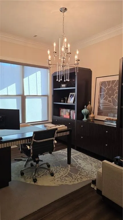 Office space with ornamental molding, wood finished floors, and a chandelier