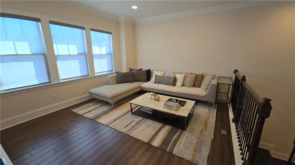 Living area featuring recessed lighting, wood finished floors, baseboards, and ornamental molding