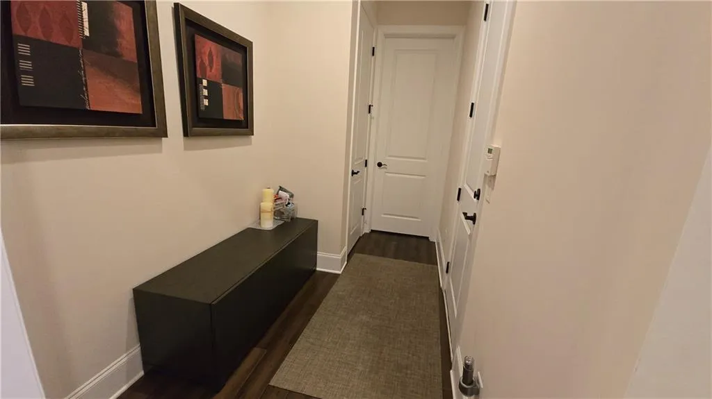 Hallway featuring baseboards and dark wood-style flooring