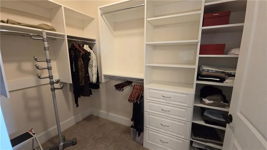Walk in closet featuring dark carpet