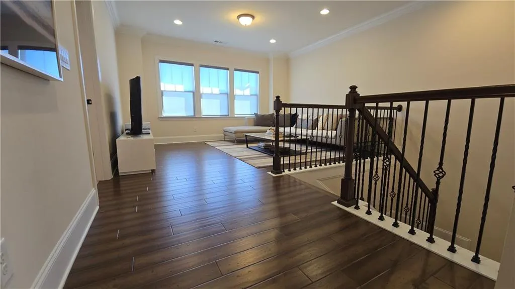 Staircase with recessed lighting, baseboards, wood finished floors, and ornamental molding