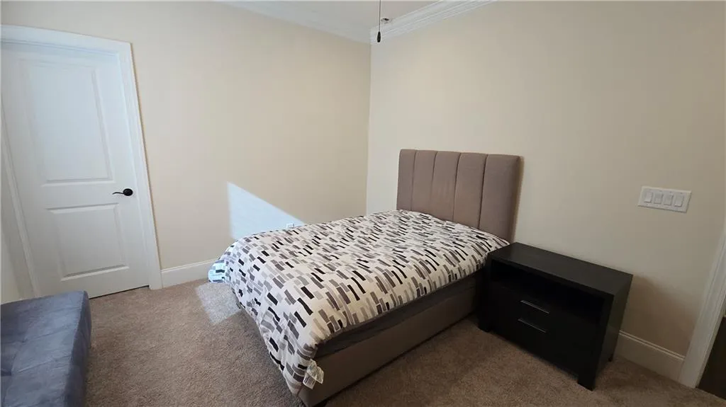Bedroom featuring ornamental molding, baseboards, and carpet floors