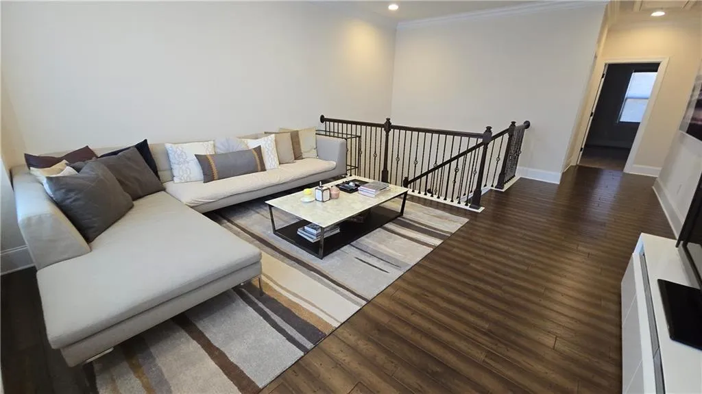 Living room with recessed lighting, baseboards, wood finished floors, and ornamental molding