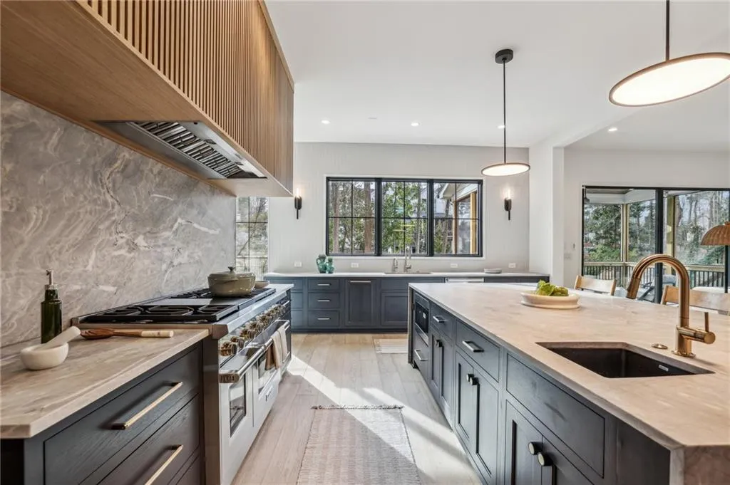 Kitchen with sink, decorative light fixtures, double oven range, and a center island