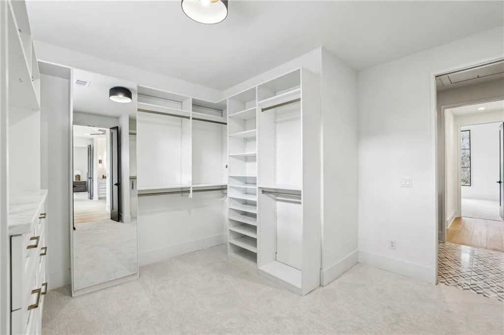 Walk in closet featuring light carpet