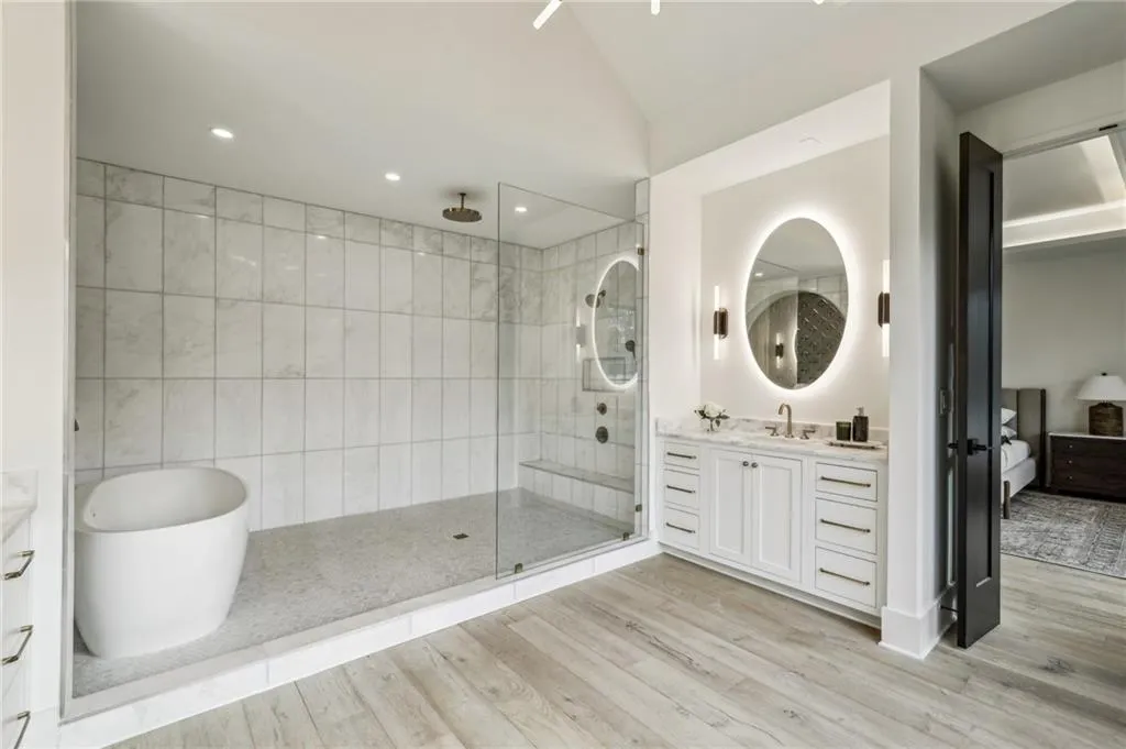 Bathroom featuring hardwood / wood-style flooring, vanity, lofted ceiling, and shower with separate bathtub