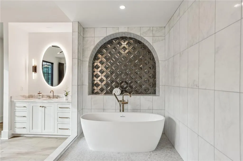 Bathroom featuring vanity, tile patterned flooring, a bathtub, and tile walls