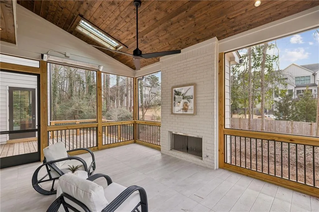 Sunroom with ceiling fan, a healthy amount of sunlight, vaulted ceiling with skylight, and wooden ceiling