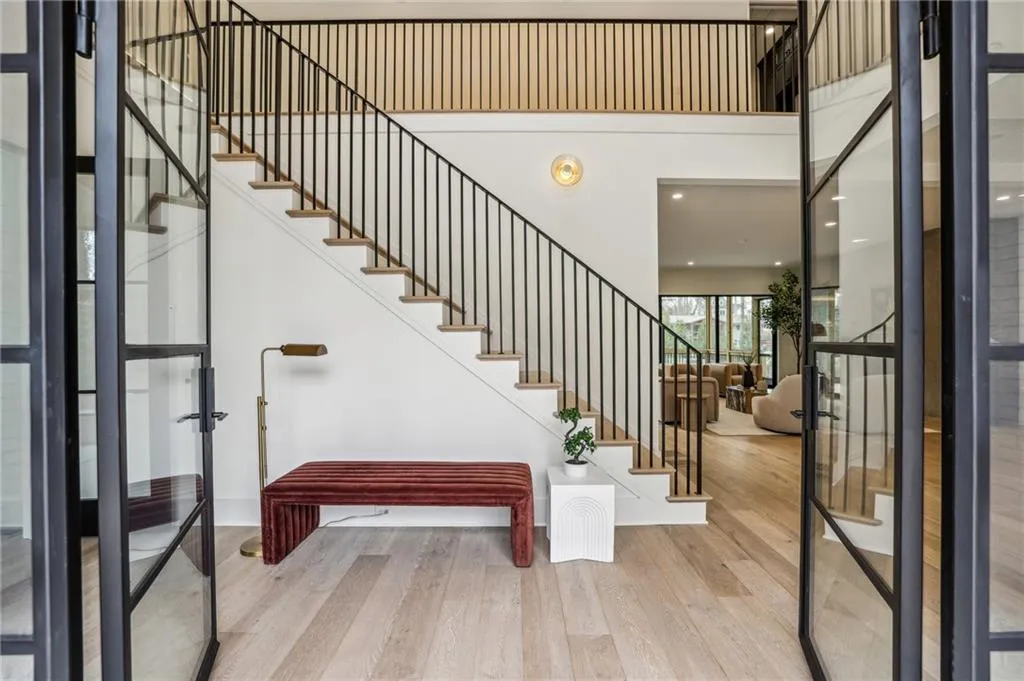 Entryway with french doors, a high ceiling, and light wood-type flooring