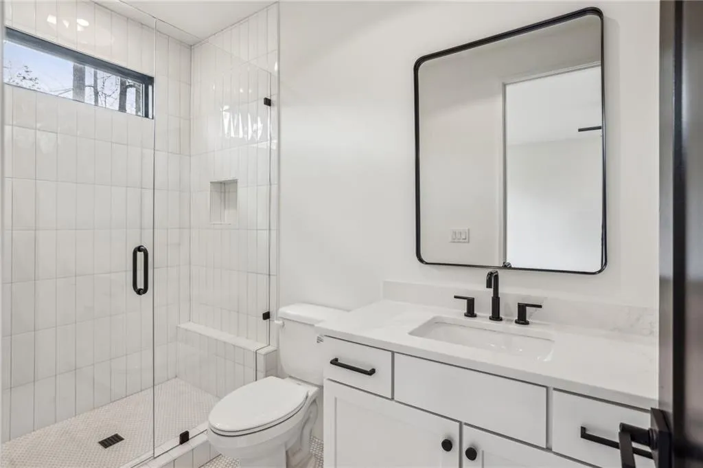 Bathroom featuring vanity, toilet, and walk in shower