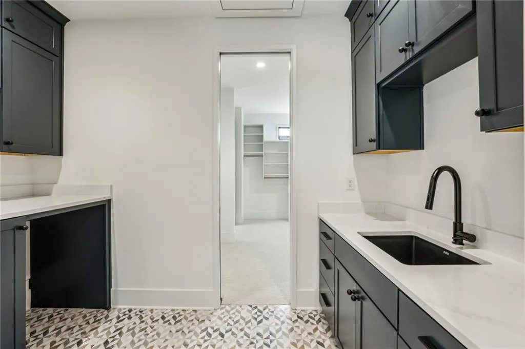 Kitchen featuring light stone counters and sink