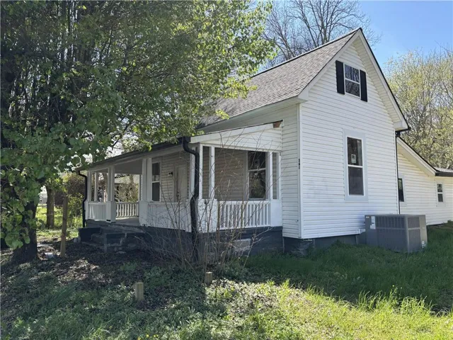 View of property exterior with a porch and roof with shingles
