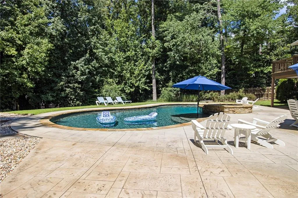 In ground heated salt water pebble tech pool with waterfall spa & wading ledge