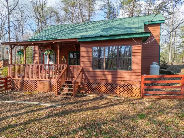 Chalet / cabin featuring a wooden deck and a metal roof