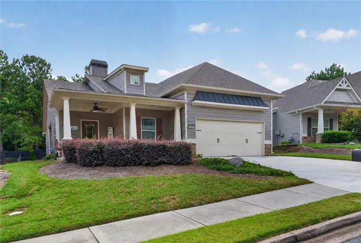 Front exterior with a covered porch, column supports, and a two-car garage (enhanced)