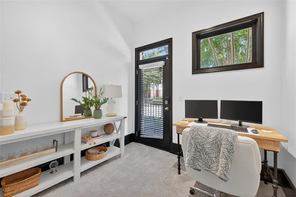 Home office with light carpet and baseboards