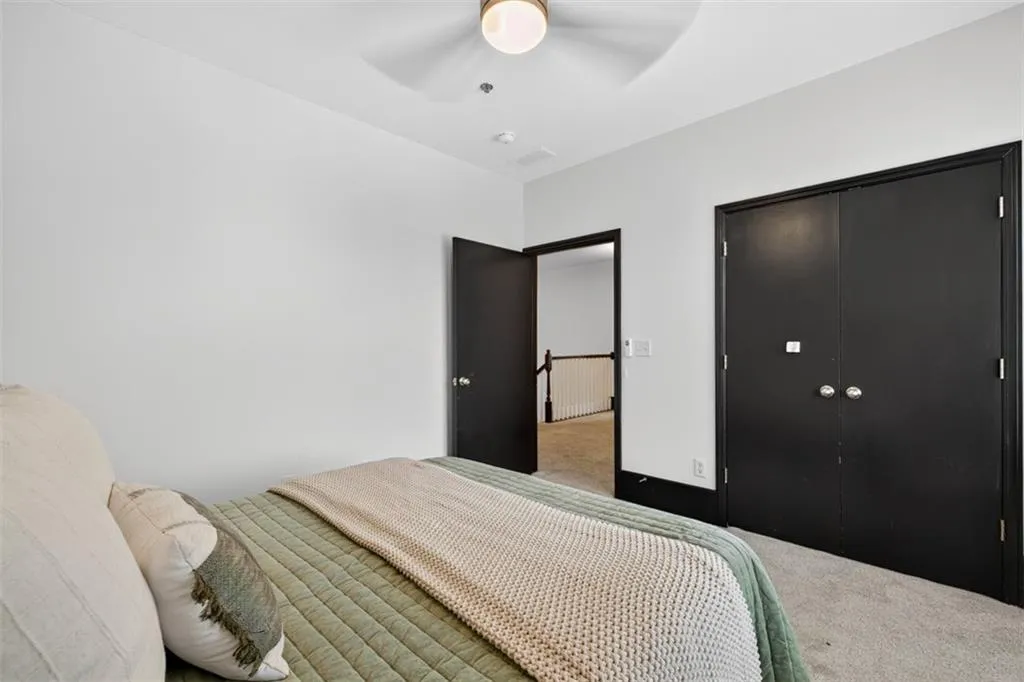 Carpeted bedroom featuring a closet and ceiling fan