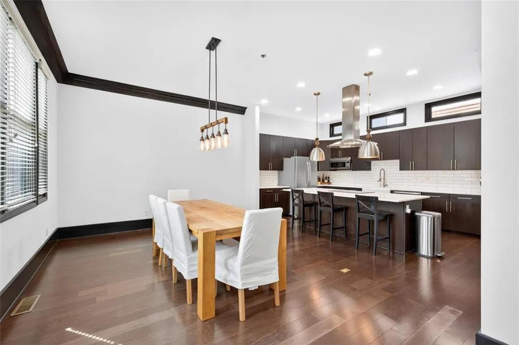 Dining space featuring dark wood-style flooring, recessed lighting, and ornamental molding