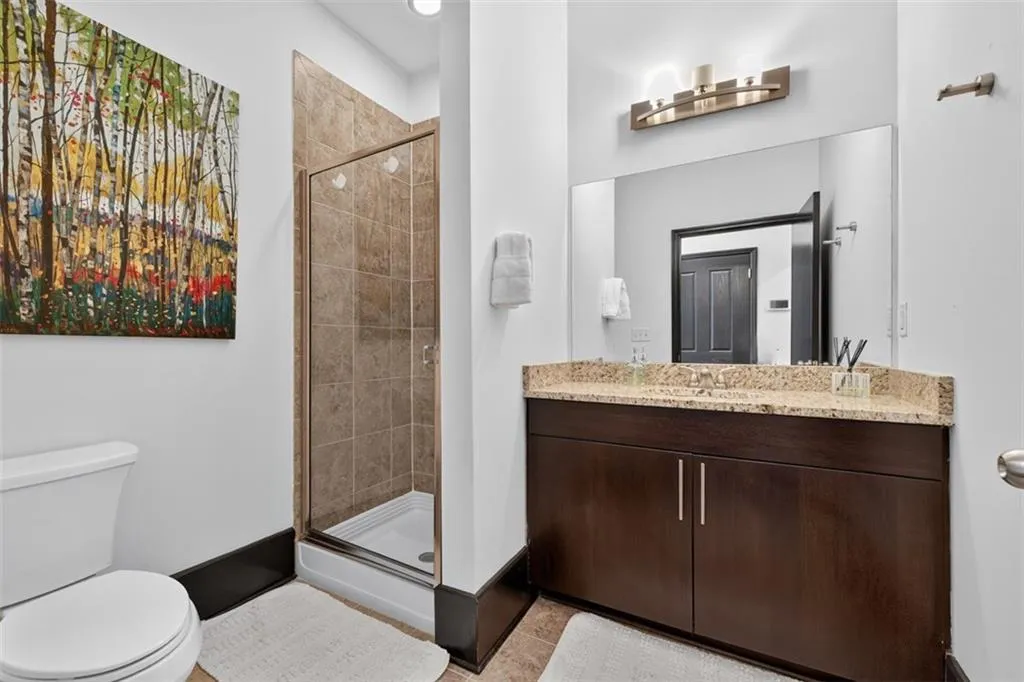 Full bath with vanity, a shower stall, and light tile patterned floors