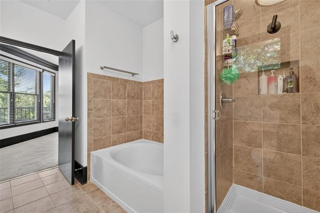 Bathroom with a shower stall, a bath, and tile patterned flooring
