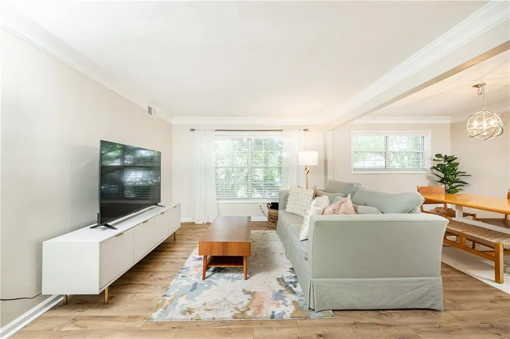 Living area featuring wood-finish flooring, crown molding, and recessed lighting