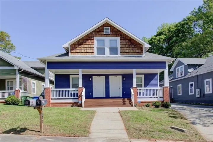 Dormer with wood shingle siding, blue horizontal siding, white trim, brick porch columns, and a porch with white railing