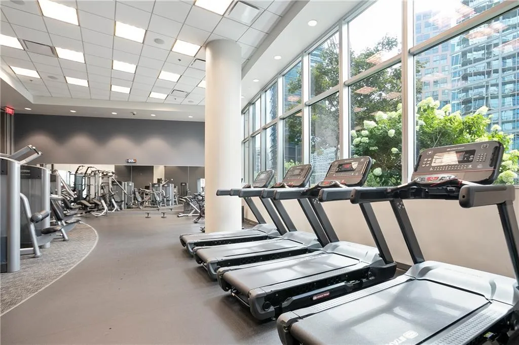 Gym with a paneled ceiling and a towering ceiling