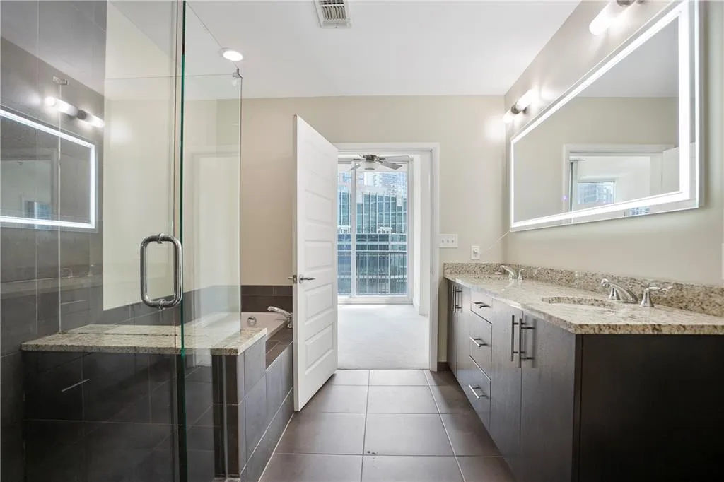 Bathroom featuring double vanity, ceiling fan, tile patterned floors, a garden tub, and a shower stall