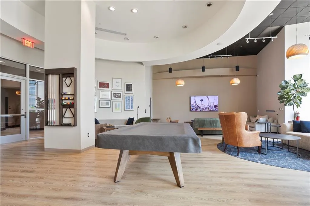 Rec room with a towering ceiling, wood finished floors, and billiards