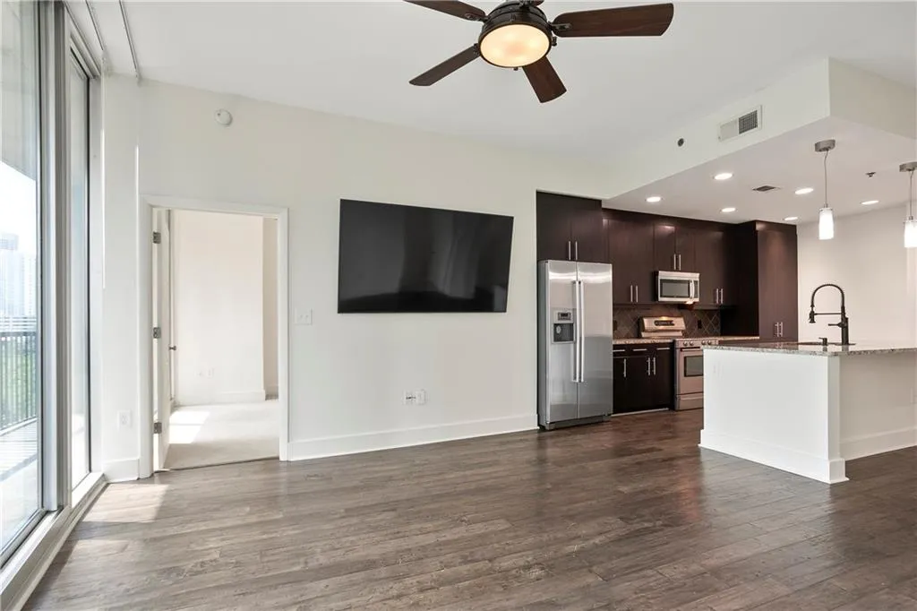 Unfurnished living room with dark wood-type flooring, a ceiling fan, and recessed lighting