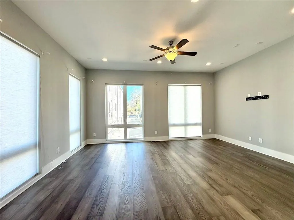 Empty room featuring recessed lighting, dark wood-style flooring, ceiling fan, and baseboards