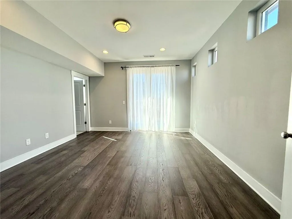 Unfurnished room with dark wood-type flooring, recessed lighting, visible vents, and baseboards